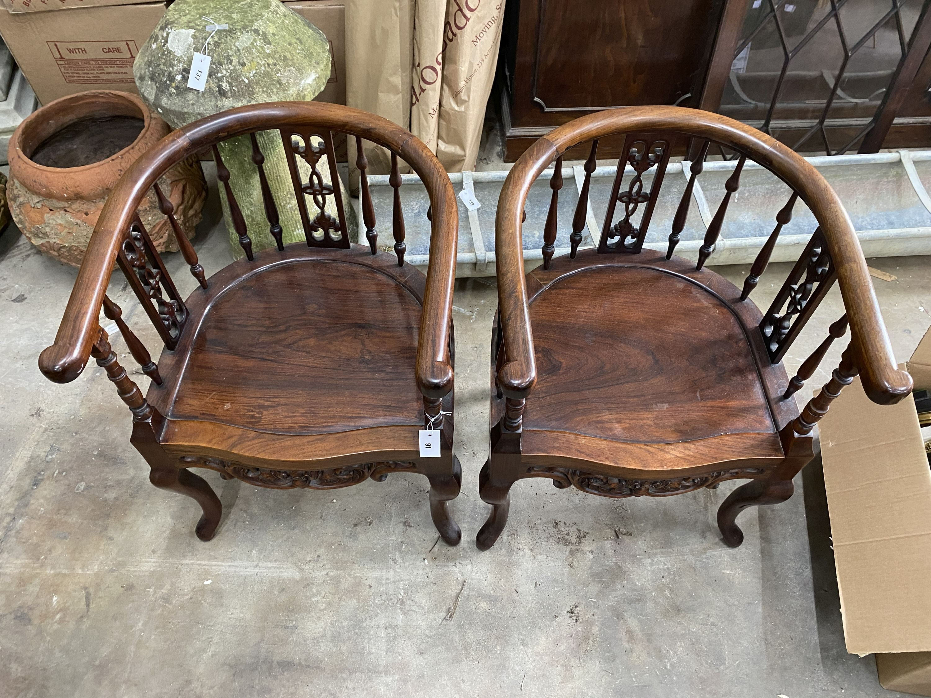 A pair of Chinese carved hardwood elbow chairs, width 55cm, depth 50cm, height 79cm